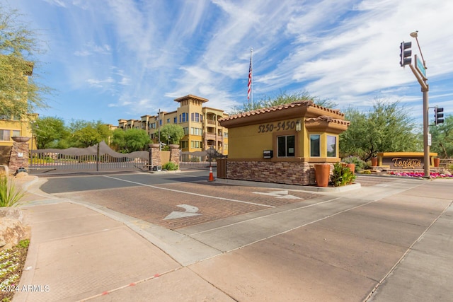 exterior space with street lighting, a gate, a gated entry, and curbs