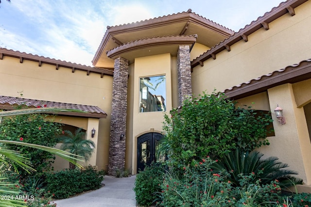 entrance to property featuring a tile roof and stucco siding