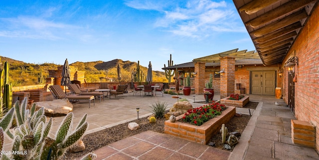 view of patio with a garden and a mountain view