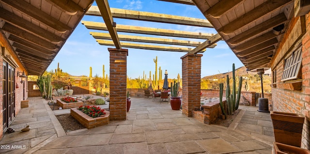 view of patio with outdoor dining area, a garden, and a pergola