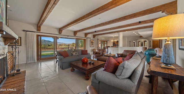 living area featuring beam ceiling, light tile patterned floors, a fireplace with raised hearth, an inviting chandelier, and baseboards