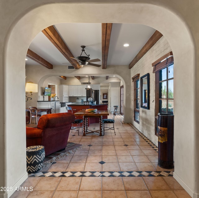 interior space featuring beam ceiling, baseboards, and light tile patterned floors