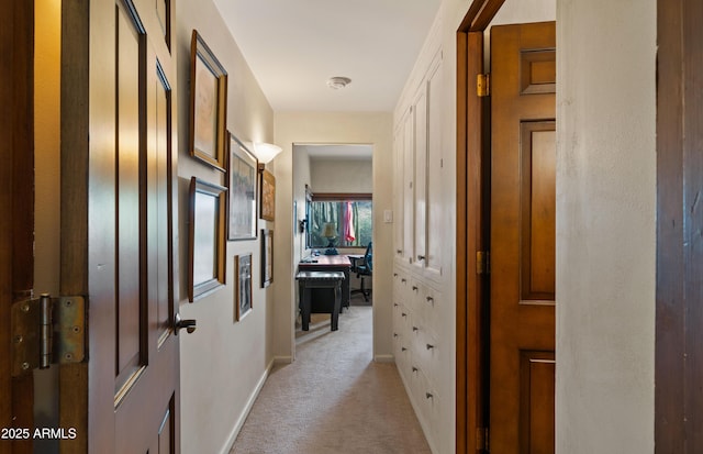 hall featuring light carpet and baseboards