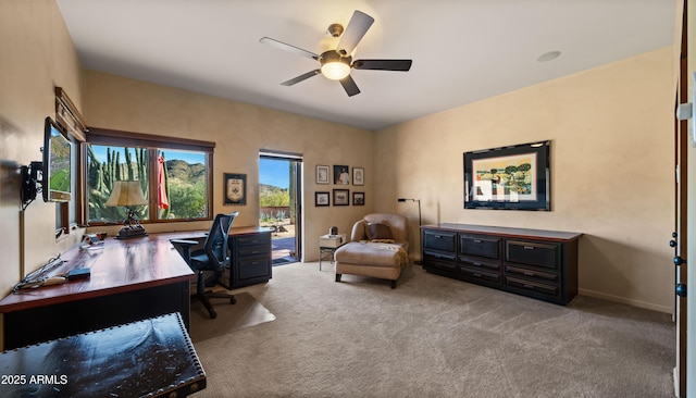 carpeted office featuring ceiling fan and baseboards