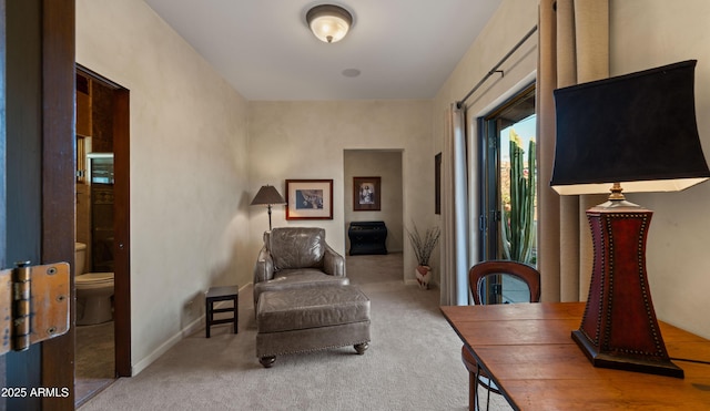 living area featuring carpet flooring and baseboards