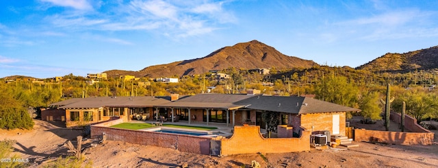 rear view of house with a mountain view and a patio