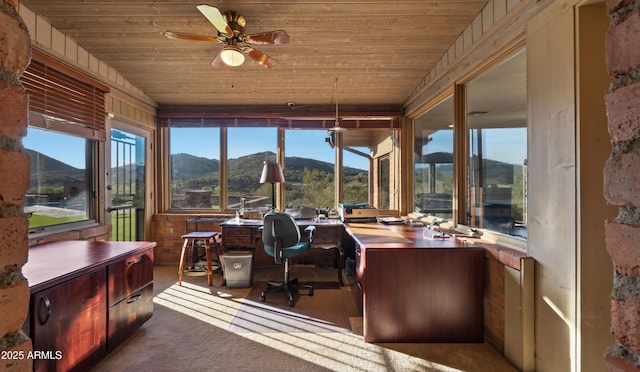 home office featuring a ceiling fan, wood ceiling, a mountain view, and carpet floors