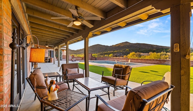 view of patio / terrace featuring a mountain view, an outdoor pool, and a ceiling fan