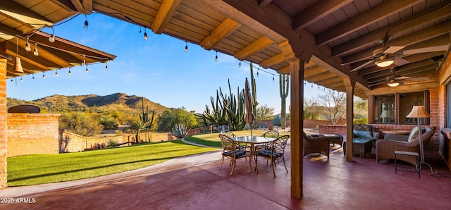 view of patio / terrace with an outdoor living space, outdoor dining area, a mountain view, and a ceiling fan