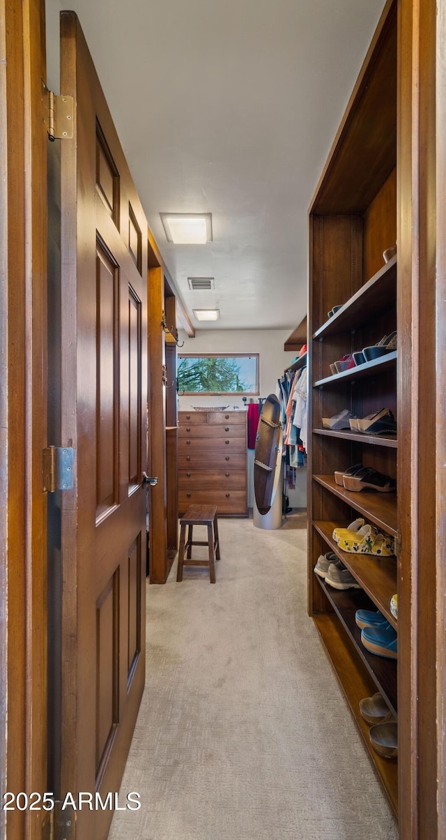 walk in closet featuring light carpet and visible vents