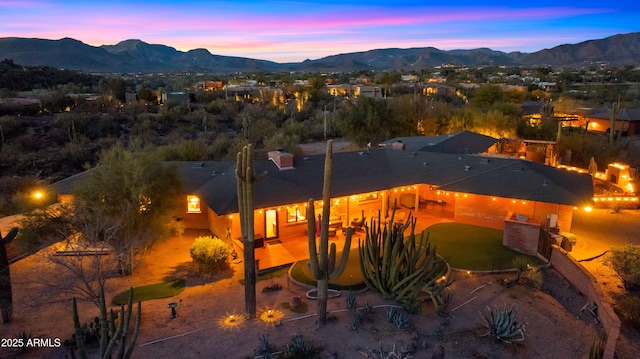 back of property at dusk featuring a mountain view