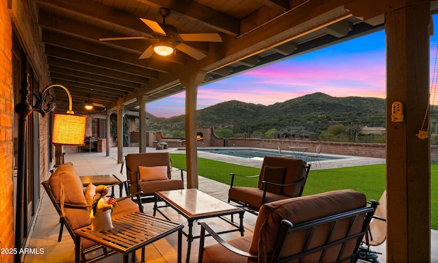 view of patio featuring a fenced in pool, a mountain view, an outdoor hangout area, and ceiling fan