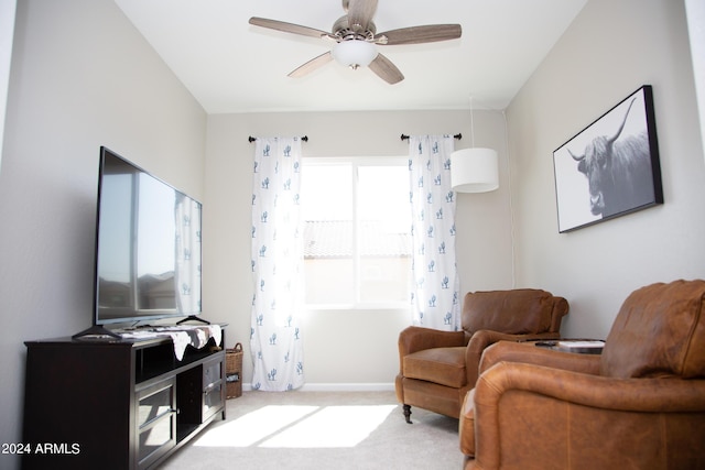 living area with ceiling fan, baseboards, and carpet flooring