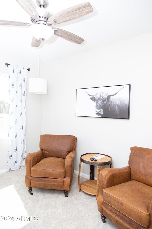 living area featuring ceiling fan, carpet flooring, and baseboards