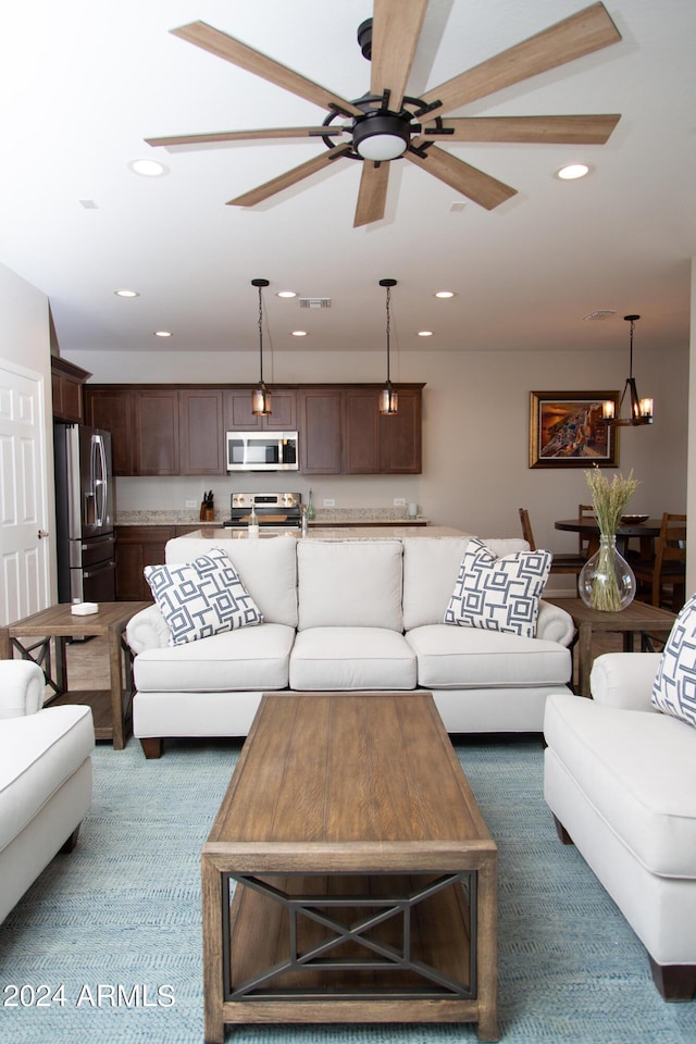 living area with recessed lighting, visible vents, carpet flooring, and ceiling fan with notable chandelier