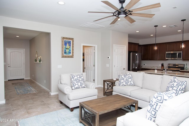 living room featuring baseboards, visible vents, and recessed lighting