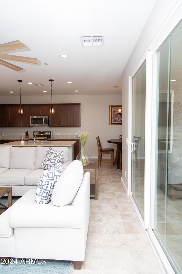 living area with baseboards, visible vents, and recessed lighting