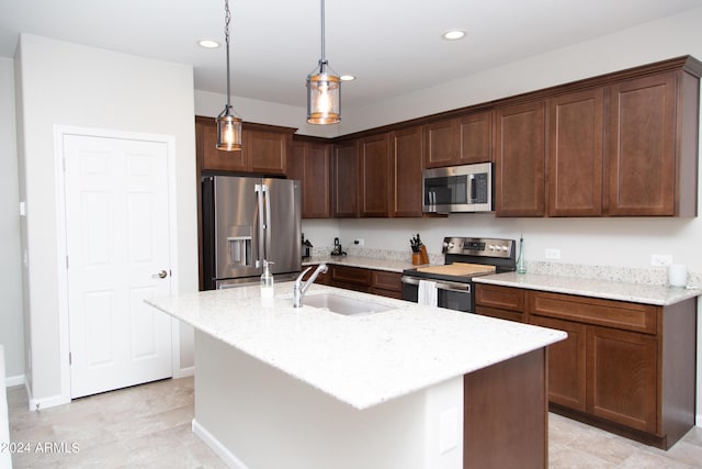 kitchen featuring light stone counters, a kitchen island with sink, recessed lighting, stainless steel appliances, and a sink