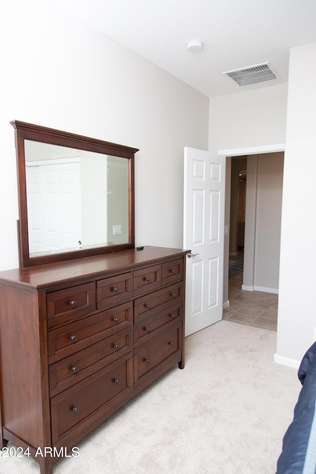 bedroom featuring baseboards, visible vents, and light colored carpet