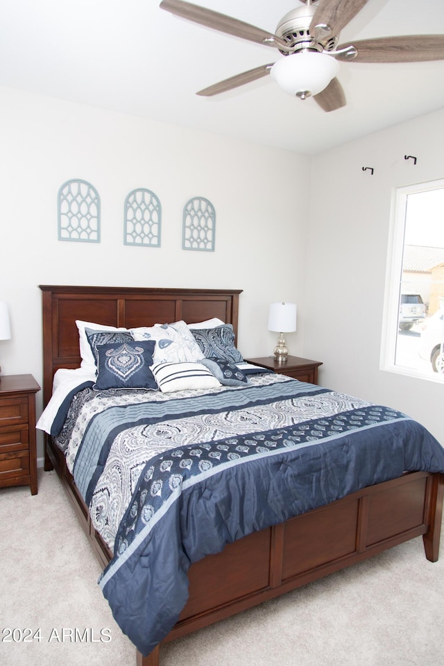 bedroom featuring light carpet and a ceiling fan