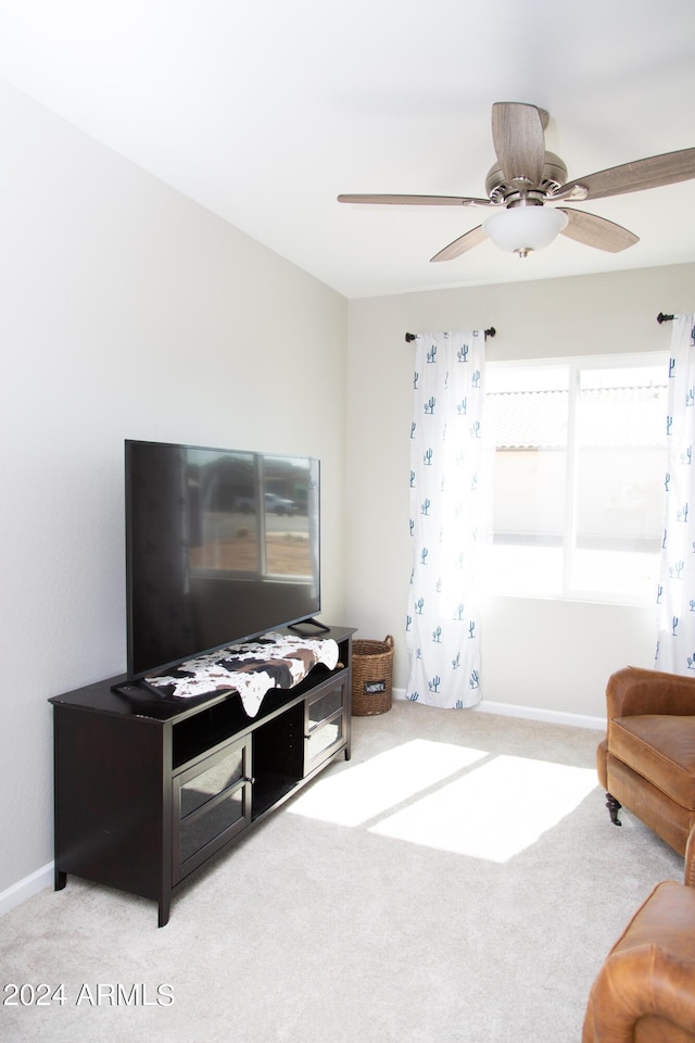 living area featuring ceiling fan, carpet floors, and baseboards