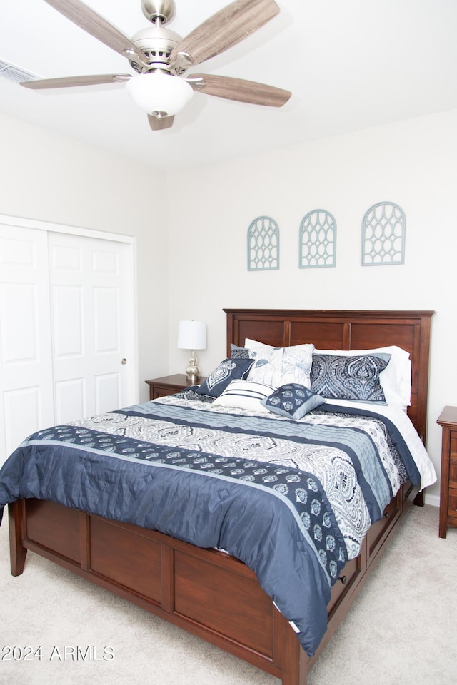 carpeted bedroom with ceiling fan, visible vents, and a closet