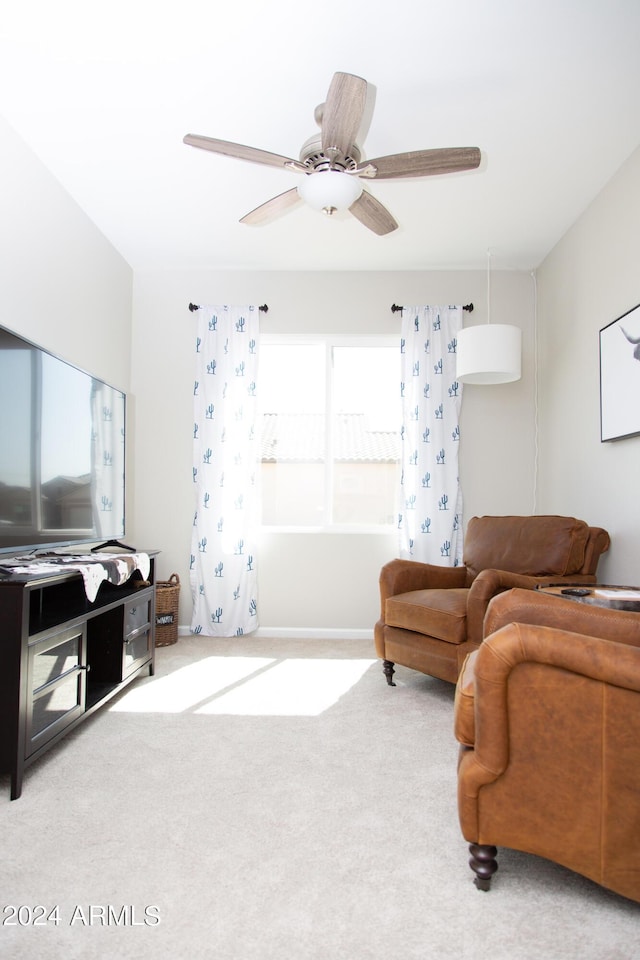 carpeted living area featuring baseboards and a ceiling fan