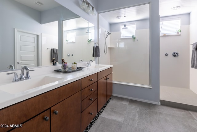 bathroom with a shower, tile patterned flooring, and vanity