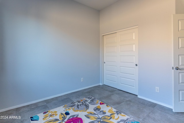 unfurnished bedroom featuring a closet and dark tile patterned floors