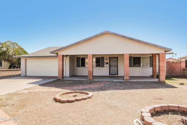 2227 N 57th Dr, Phoenix, AZ 85035 - ranch-style home with covered porch, driveway, an attached garage, and an outdoor fire pit