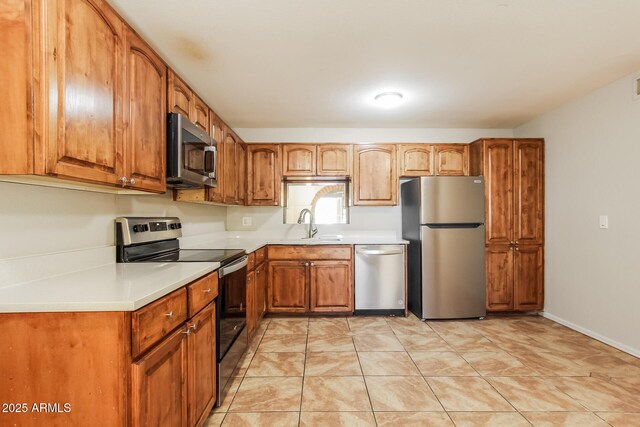 2227 N 57th Dr, Phoenix, AZ 85035 - kitchen with appliances with stainless steel finishes, light countertops, brown cabinets, and a sink