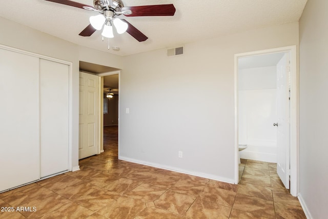2227 N 57th Dr, Phoenix, AZ 85035 - unfurnished bedroom with a closet, ensuite bath, light tile patterned floors, a ceiling fan, and baseboards