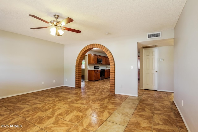 2227 N 57th Dr, Phoenix, AZ 85035 - empty room featuring a ceiling fan, a textured ceiling, arched walkways, and baseboards