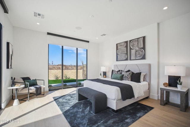 bedroom with wood-type flooring and access to outside