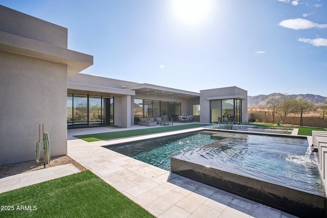 view of swimming pool with a mountain view, a patio, pool water feature, and an outdoor hangout area