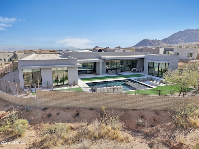 rear view of property featuring a mountain view, a fenced in pool, and a patio area