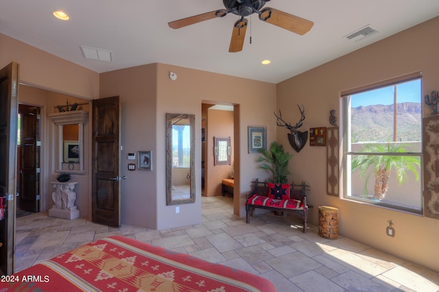 bedroom with a mountain view, ceiling fan, and ensuite bathroom