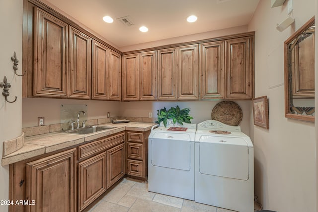 laundry room featuring cabinets, separate washer and dryer, and sink