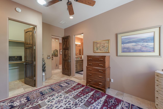 bedroom with a spacious closet, connected bathroom, ceiling fan, and a closet