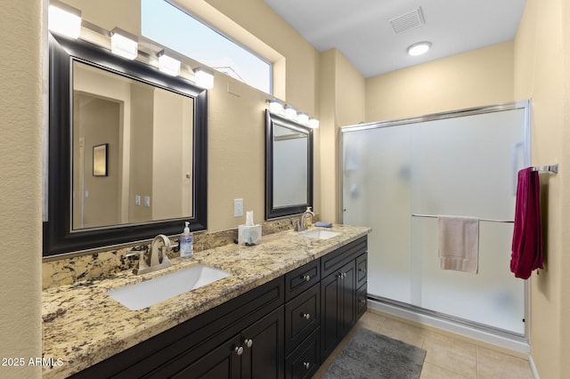 bathroom featuring tile patterned flooring, vanity, and a shower with shower door