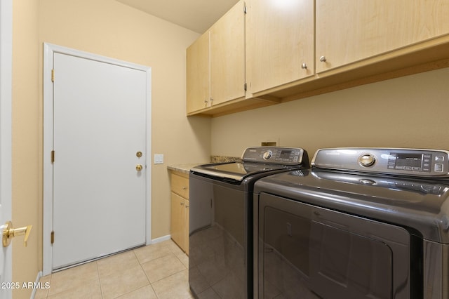 washroom with cabinets, light tile patterned flooring, and washer and clothes dryer