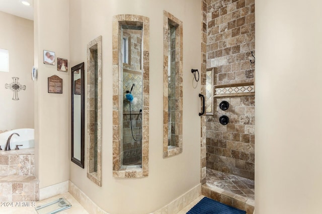 bathroom with tile patterned flooring and tiled shower