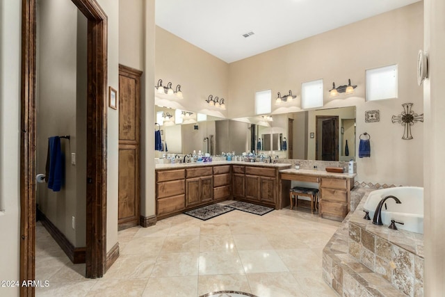 bathroom featuring tiled tub and vanity