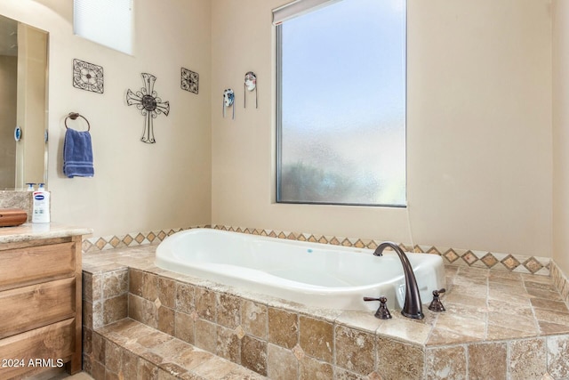 bathroom with vanity and tiled tub