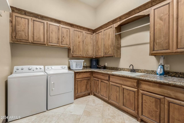 laundry room featuring washer and dryer, cabinets, light tile patterned floors, and sink