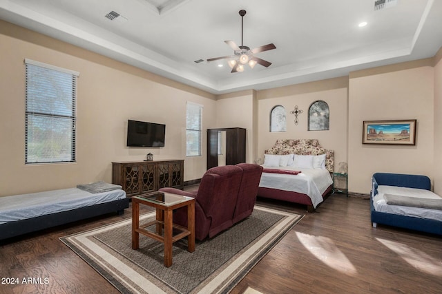 bedroom featuring a tray ceiling, ceiling fan, and dark wood-type flooring