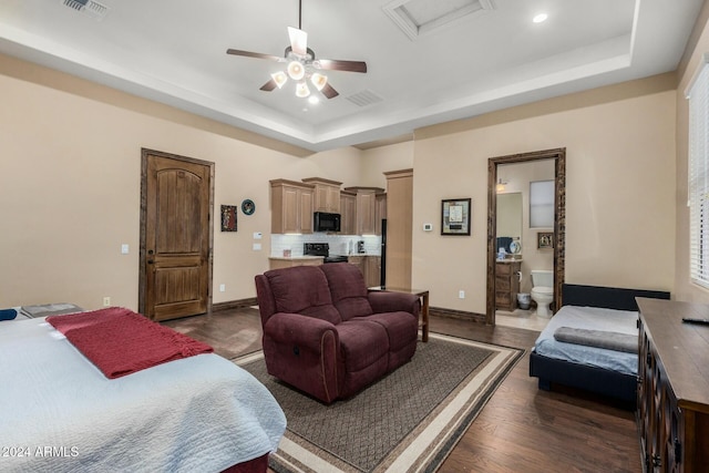 living room with dark hardwood / wood-style flooring, a raised ceiling, and ceiling fan