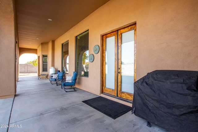 view of exterior entry with a patio and french doors