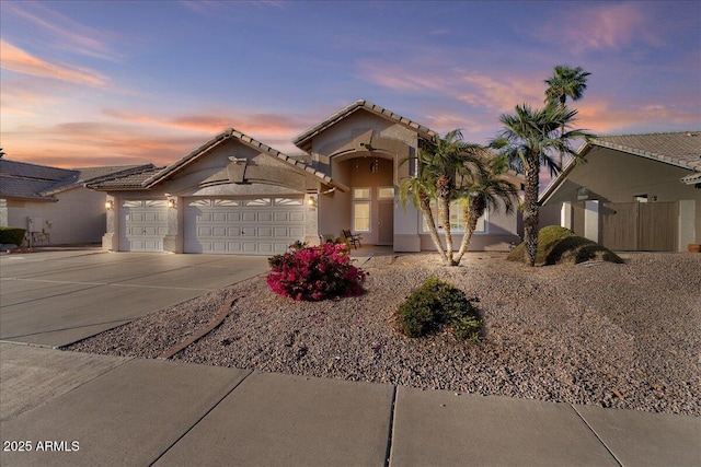 view of front of home featuring an attached garage, concrete driveway, and stucco siding