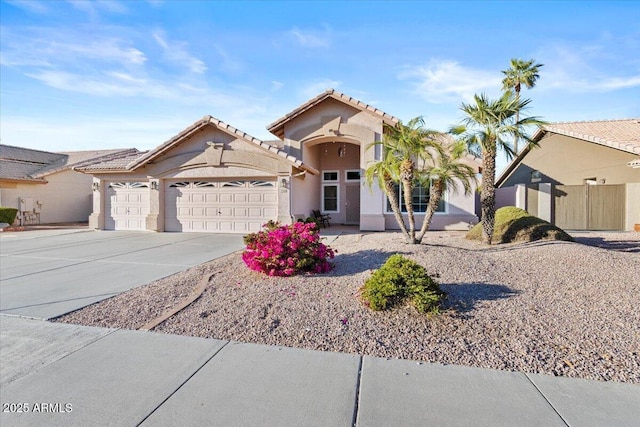 view of front of house featuring an attached garage, a tiled roof, concrete driveway, and stucco siding